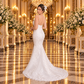 Vista posterior de tres cuartos del vestido de novia 51BBCM23LQ corte sirena en ivory, sin la cauda adicional, con botonadura y cola propia del vestido.